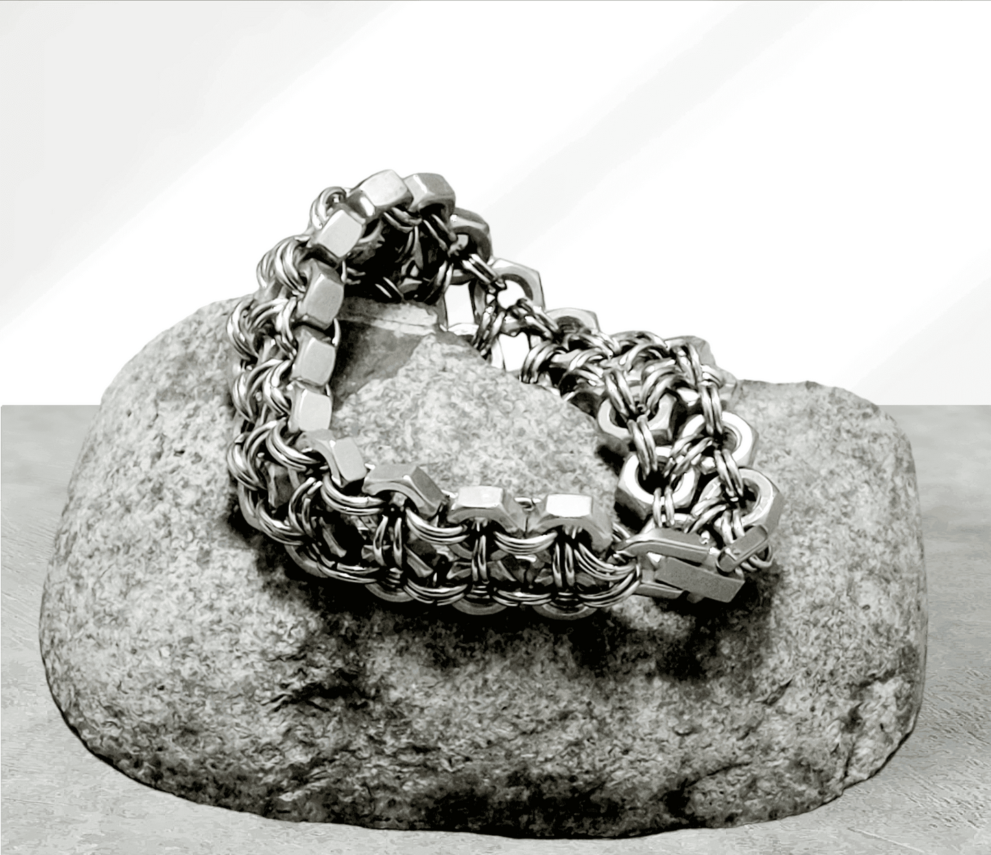 Silver chain cuff cuff bracelet with hexagonal links displayed on a gray stone by Nutz n Chains