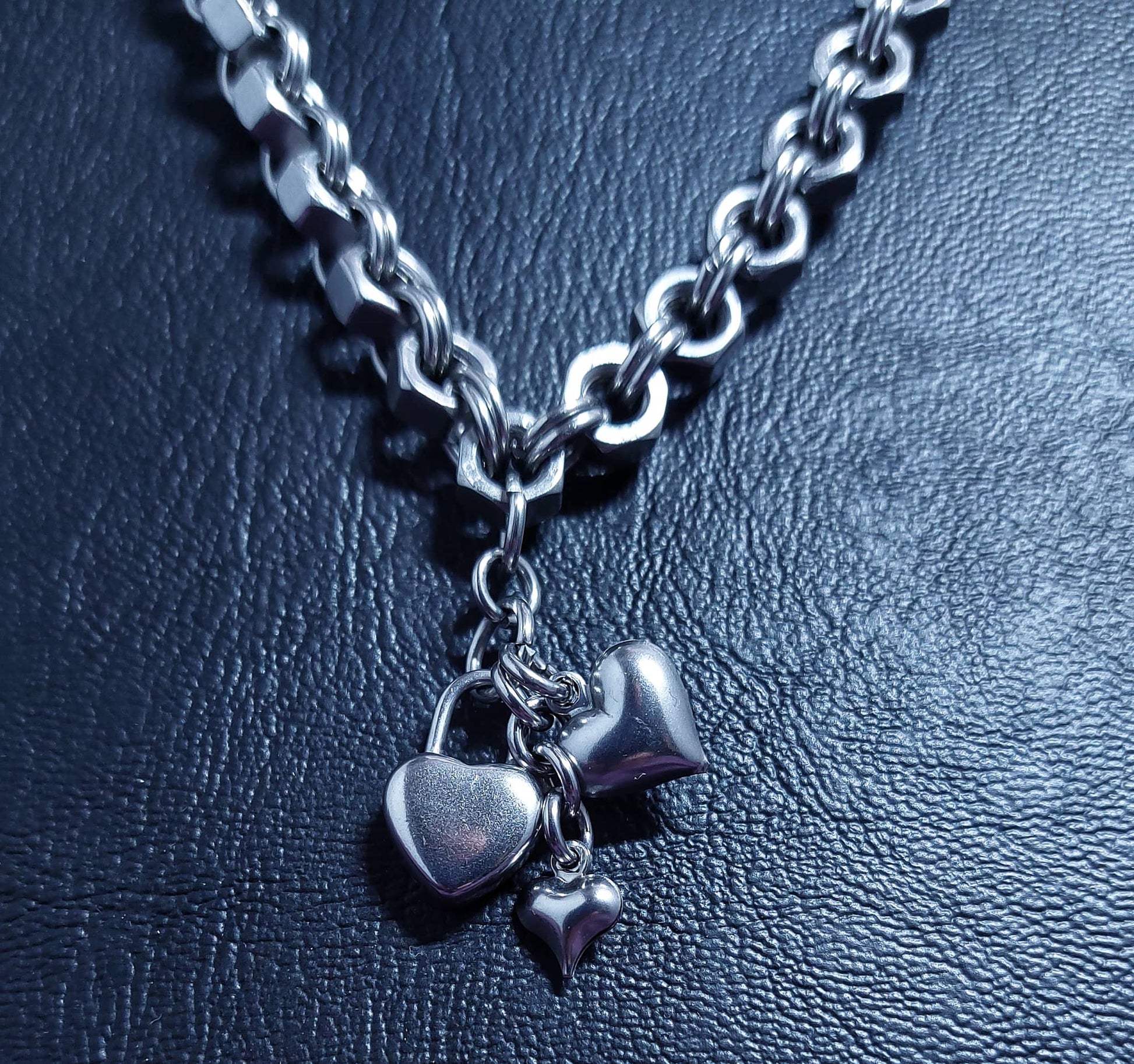 Silver heart-shaped charms for charm necklace hanging on chunky silver chain necklace by Nutz n Chains