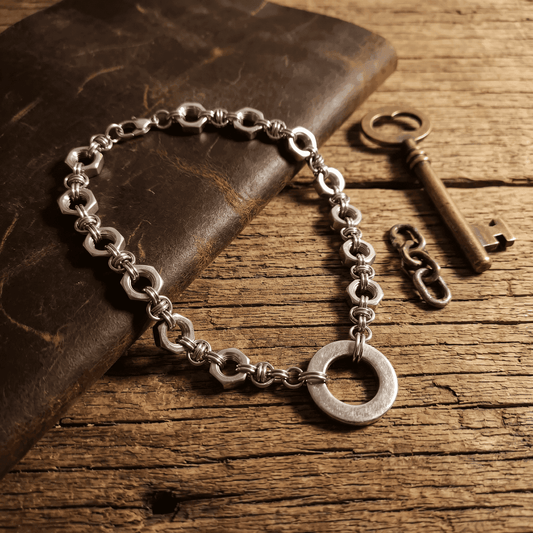 Nutz n Chains stainless steel choker with interlocking links and circular clasp on rustic wooden surface